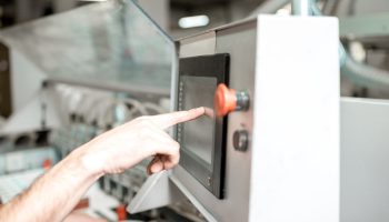 Pushing the button of the gluing machine which clings the label on the paper tube